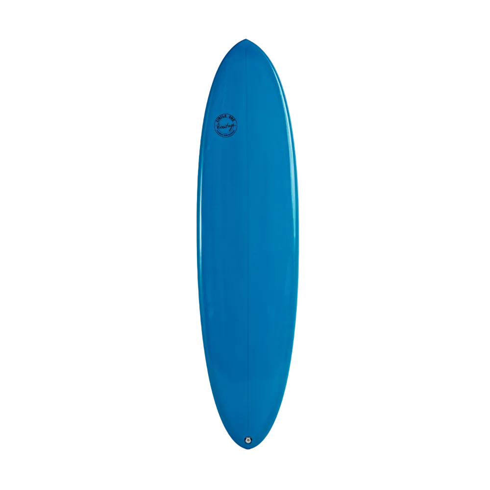 A bright blue egg surfboard standing vertically against a plain white wall, with a small circular logo near the top center.
