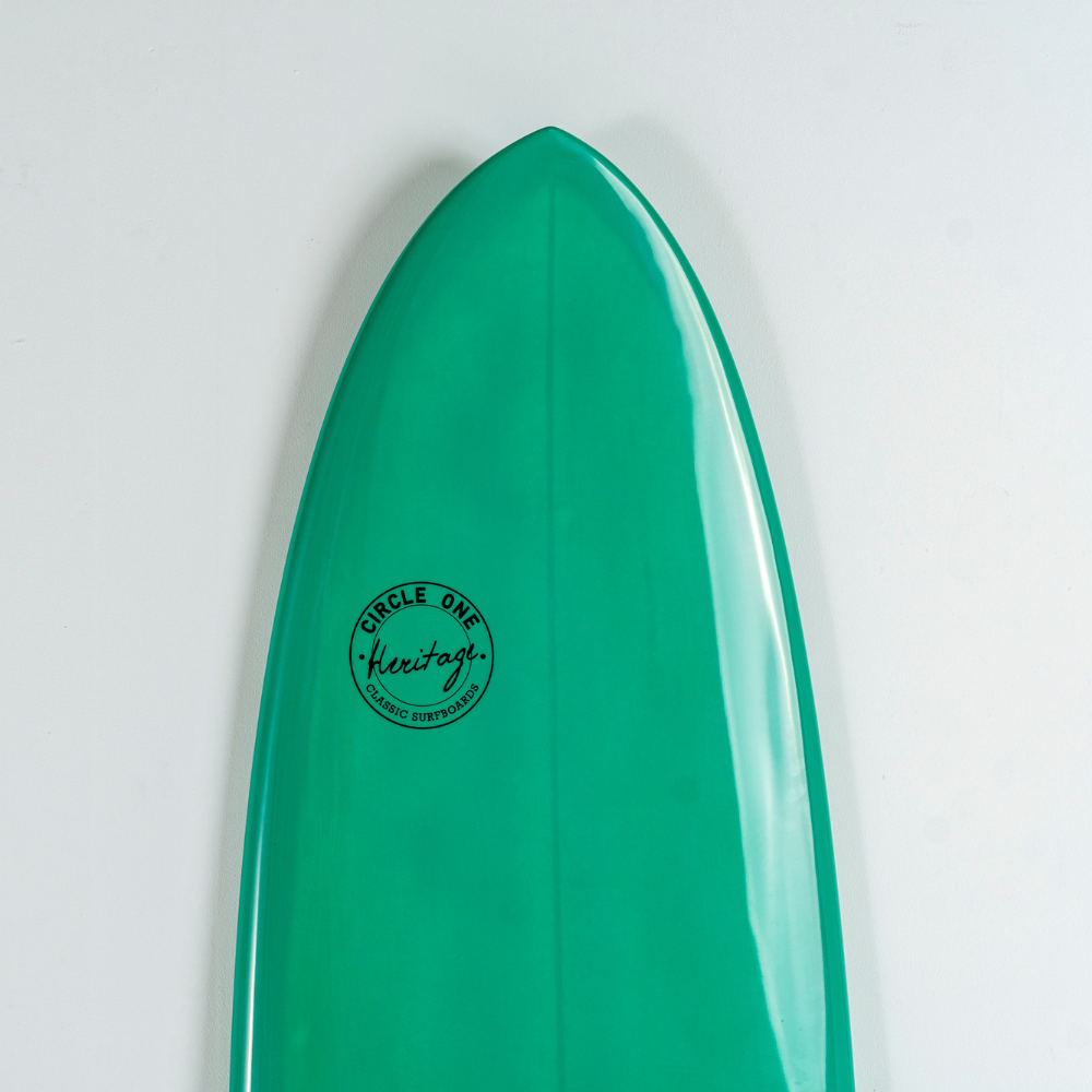 A close-up of a glossy green egg surfboard tip against a plain white background, featuring a circular black 'Circle One Keeso' logo.